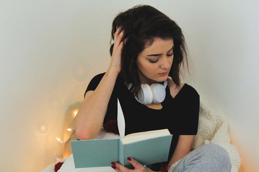 5 Key Insights gained by reviewing your journal girl sitting thinking with book