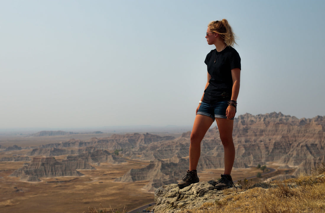 Woman in black t-shirt and black shorts standing on brown grass field